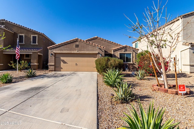 mediterranean / spanish home featuring a garage, stucco siding, driveway, and a tile roof