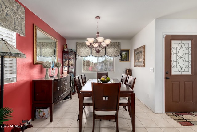 dining space featuring light tile patterned floors and an inviting chandelier