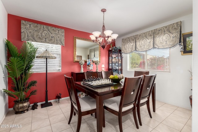 tiled dining space featuring a chandelier and baseboards