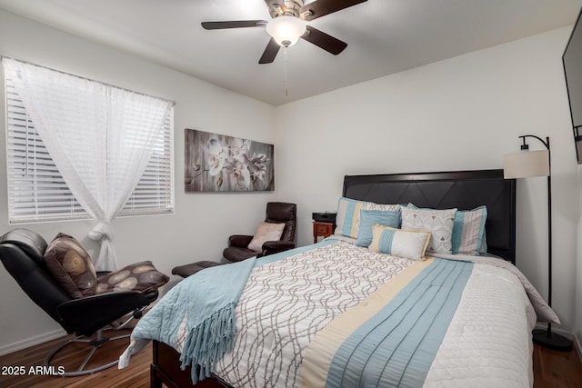 bedroom with a ceiling fan, wood finished floors, and baseboards