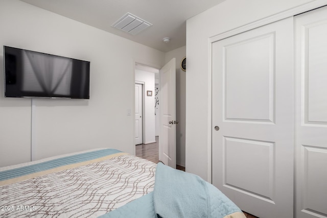 bedroom featuring a closet, visible vents, and wood finished floors