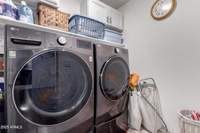 clothes washing area featuring cabinet space and separate washer and dryer