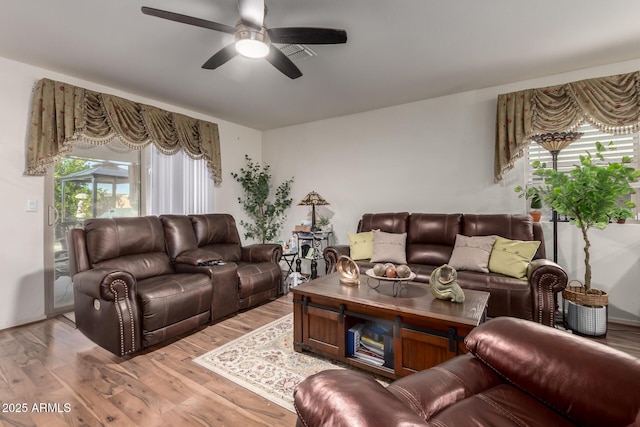 living room with visible vents, ceiling fan, and light wood-style floors