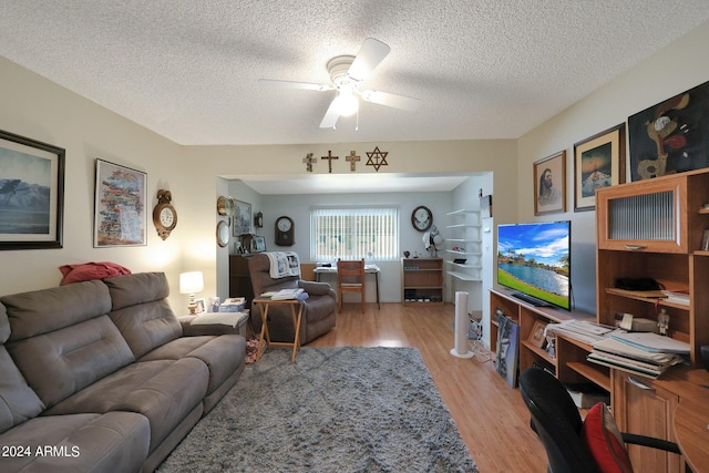 living area featuring ceiling fan, a textured ceiling, and light wood finished floors