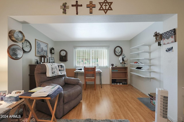 living area featuring heating unit and wood finished floors