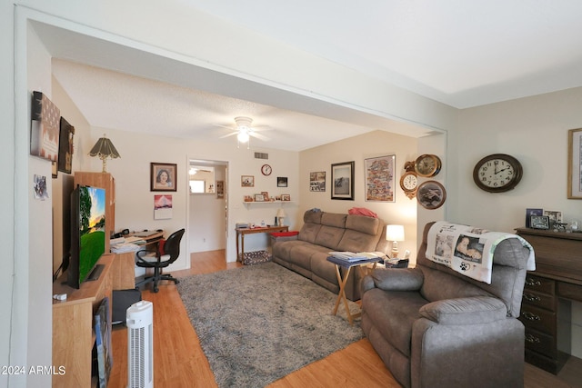 living room with a ceiling fan, visible vents, and wood finished floors