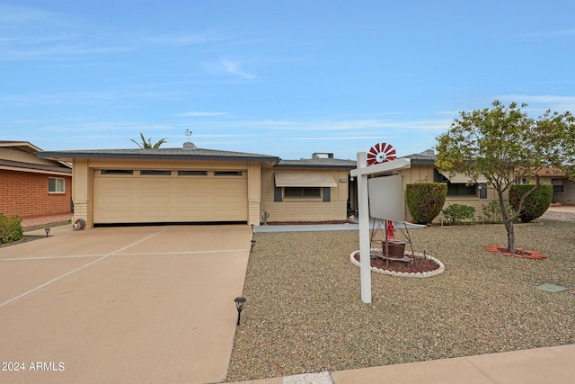 ranch-style house featuring an attached garage, concrete driveway, and brick siding