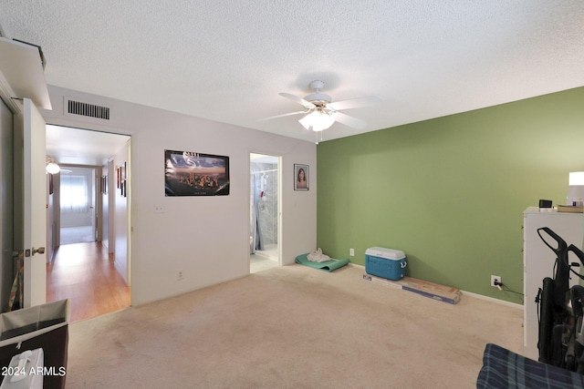 interior space featuring a textured ceiling, visible vents, and a ceiling fan