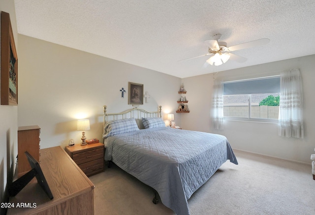 bedroom with a textured ceiling, carpet, and a ceiling fan