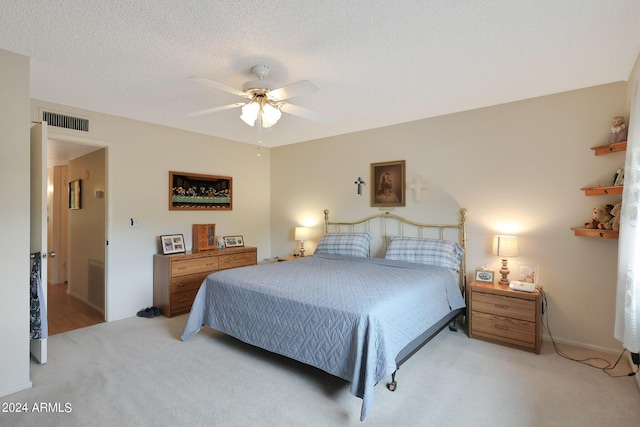 bedroom with visible vents, ceiling fan, a textured ceiling, and carpet flooring