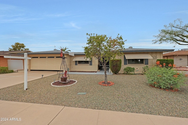 ranch-style home featuring concrete driveway, brick siding, and an attached garage