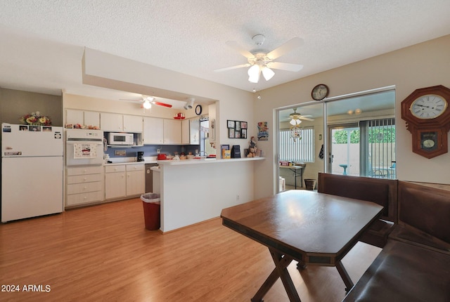 dining space with a textured ceiling, ceiling fan, and light wood-style flooring