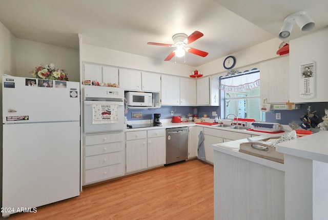 kitchen featuring white appliances, light countertops, a sink, and light wood finished floors