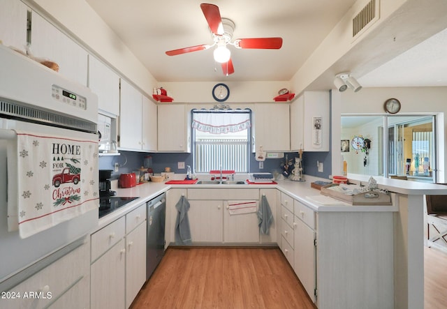 kitchen with light wood-style flooring, a peninsula, visible vents, light countertops, and stainless steel dishwasher