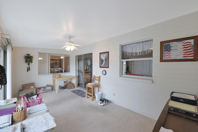 living area featuring carpet flooring and ceiling fan