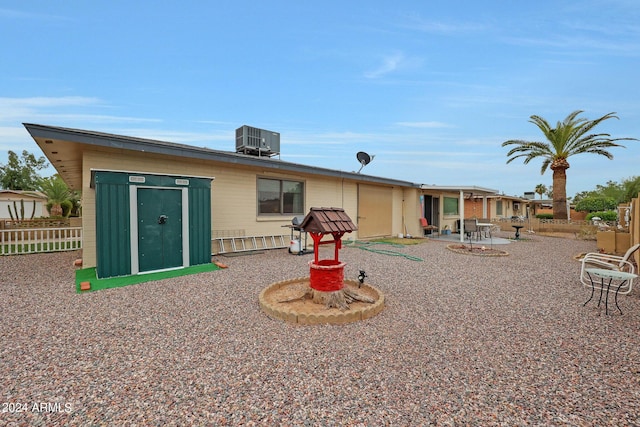 rear view of property featuring a patio area, fence, and central air condition unit