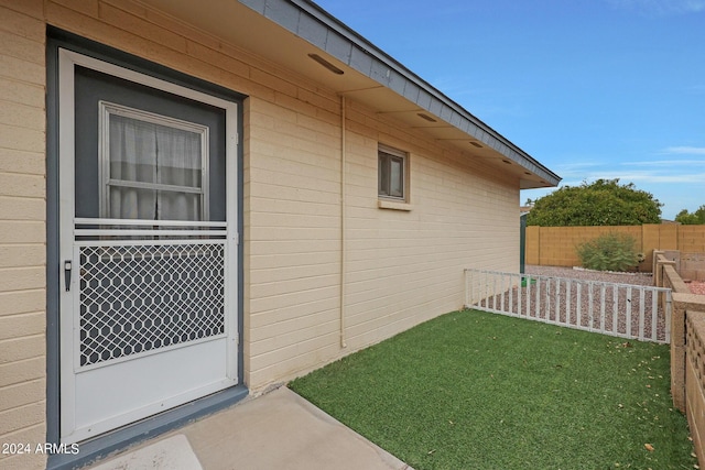 view of home's exterior featuring fence and a lawn