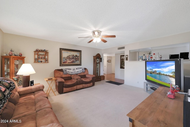 carpeted living area featuring a ceiling fan, visible vents, and a textured ceiling