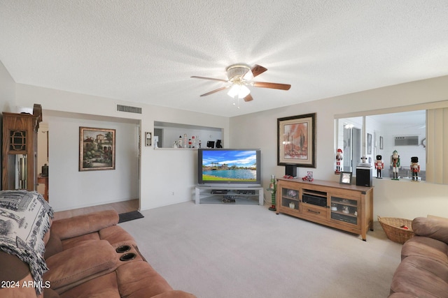 living area with a ceiling fan, visible vents, a textured ceiling, and carpet flooring