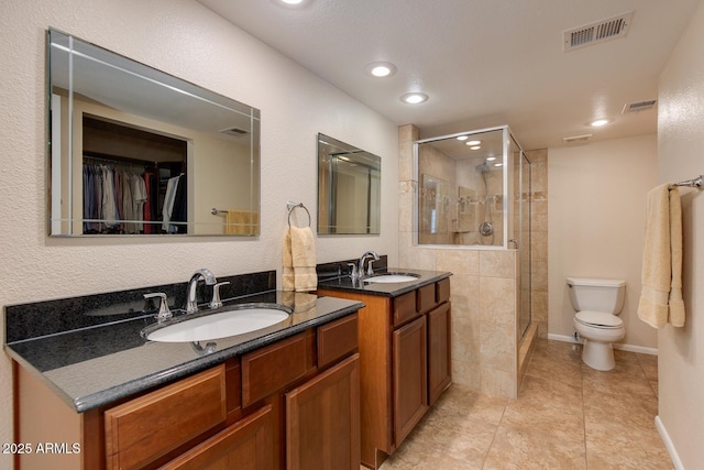 bathroom featuring vanity, toilet, tile patterned floors, and walk in shower