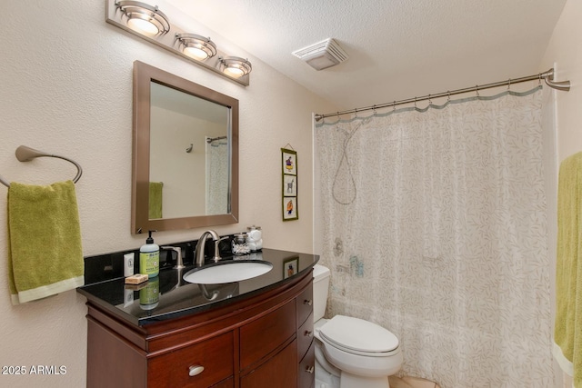 bathroom with vanity, toilet, and a textured ceiling