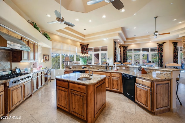 kitchen featuring backsplash, a tray ceiling, a spacious island, sink, and dishwasher