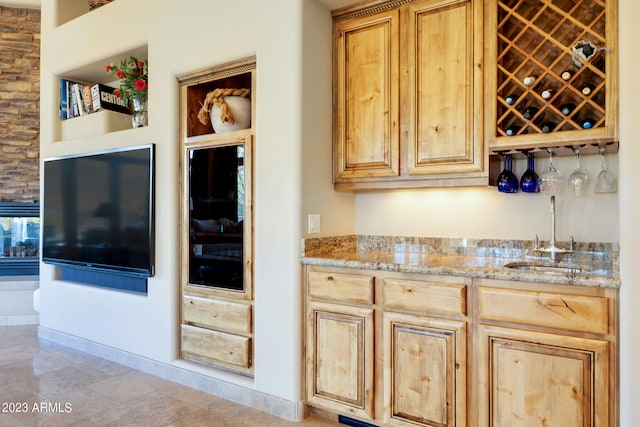 kitchen featuring light stone counters and sink