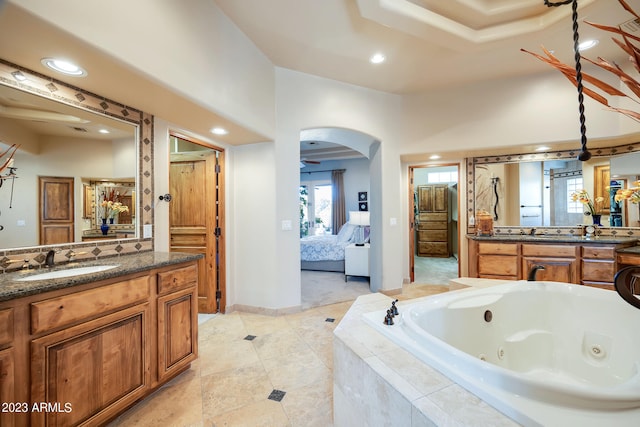 bathroom featuring vanity and tiled bath