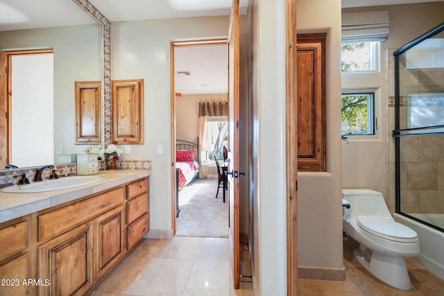 full bathroom with tile patterned floors, vanity, bath / shower combo with glass door, and toilet