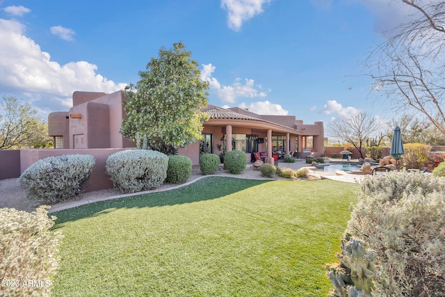 rear view of house with a yard and a patio