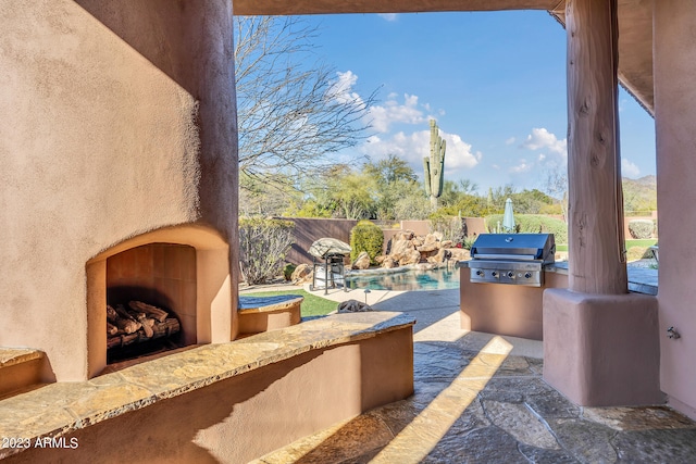 view of patio with a fenced in pool, area for grilling, and exterior fireplace