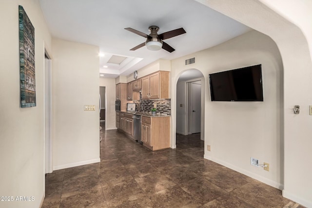 kitchen with ceiling fan, dishwasher, tasteful backsplash, a raised ceiling, and light brown cabinets