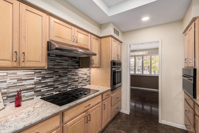 kitchen with light brown cabinetry, black stovetop, and stainless steel oven