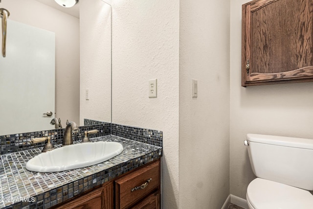 bathroom featuring tasteful backsplash, vanity, and toilet