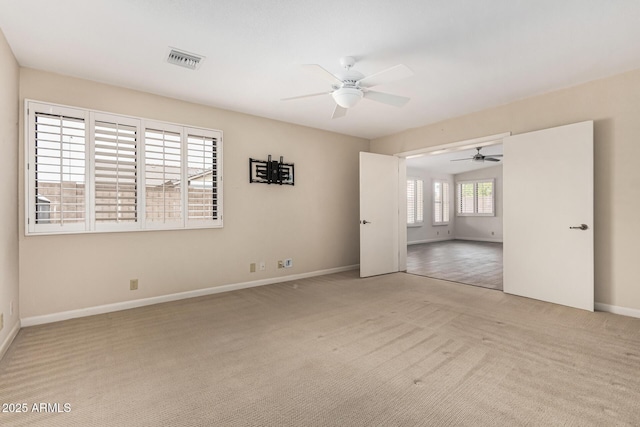 spare room featuring light colored carpet and ceiling fan