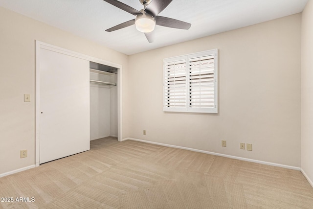 unfurnished bedroom featuring light colored carpet, a closet, and ceiling fan