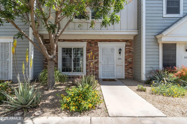 entrance to property featuring board and batten siding and brick siding