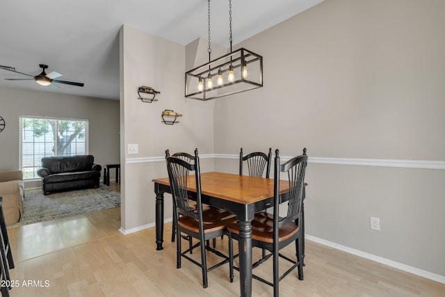 dining room featuring baseboards, a ceiling fan, and light wood-type flooring