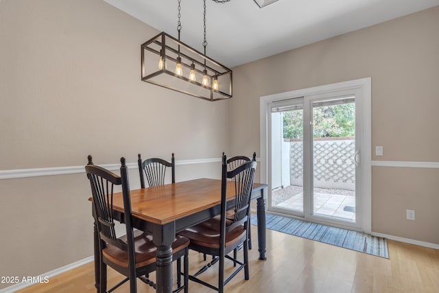 dining space with light wood-style floors and baseboards