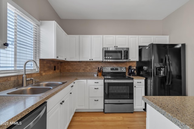 kitchen featuring white cabinets, stainless steel appliances, and a sink