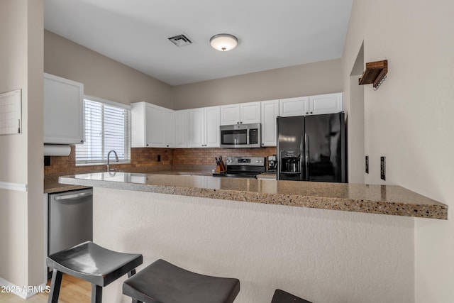 kitchen featuring white cabinetry, tasteful backsplash, and stainless steel appliances