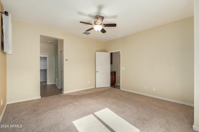 unfurnished bedroom with carpet, ceiling fan, a spacious closet, and a closet