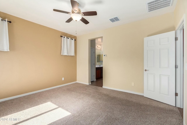 unfurnished bedroom featuring carpet flooring, ensuite bathroom, and ceiling fan