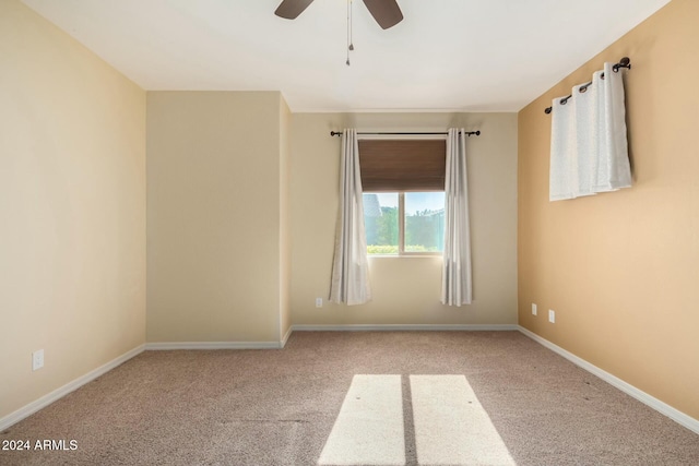 carpeted spare room featuring ceiling fan