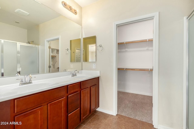 bathroom with tile patterned floors, vanity, and a shower with shower door