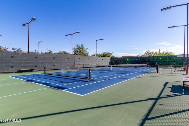 view of tennis court with basketball hoop