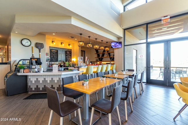 dining space featuring french doors, dark hardwood / wood-style flooring, and a high ceiling