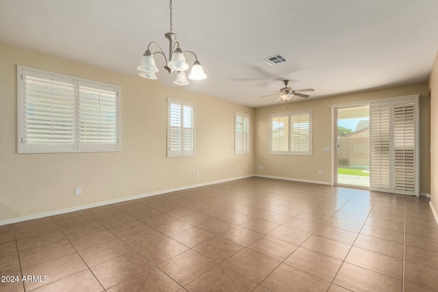 spare room with ceiling fan with notable chandelier and light tile patterned floors