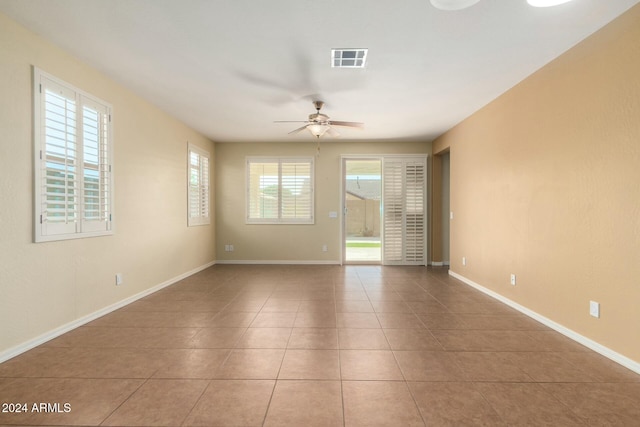 tiled spare room featuring ceiling fan and plenty of natural light