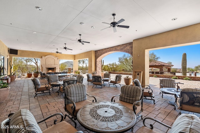 8633 E Kael Cir, Mesa, AZ 85207 - view of patio / terrace featuring an outdoor living space with a fireplace, a ceiling fan, and outdoor dining space